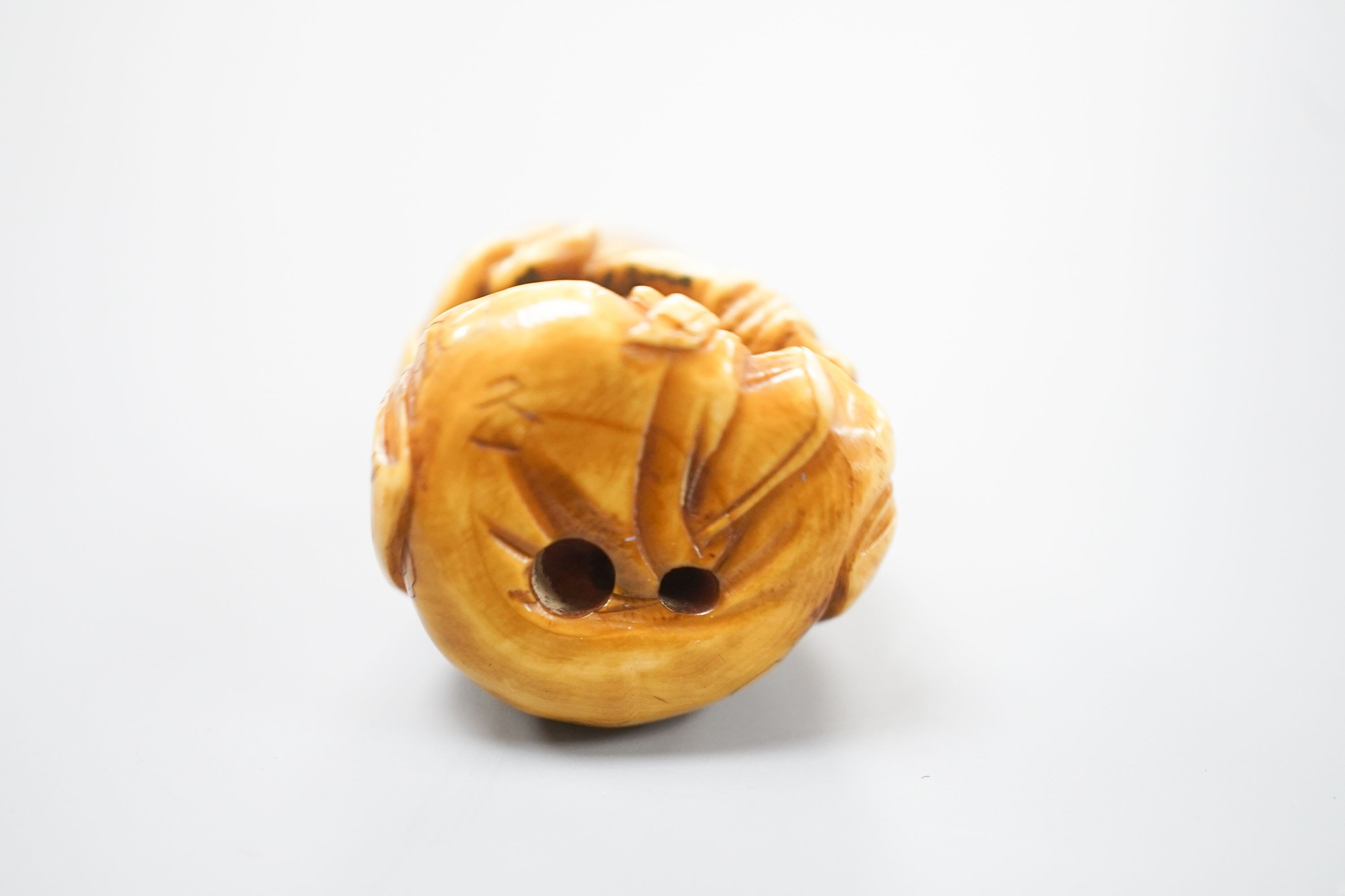 A Japanese ivory netsuke of Fukurokuju seated, holding a sceptre, early 20th century, 3.8cm